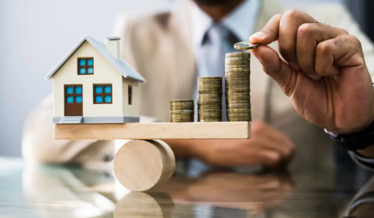 Stacks of coins in front of house models with percentage symbols