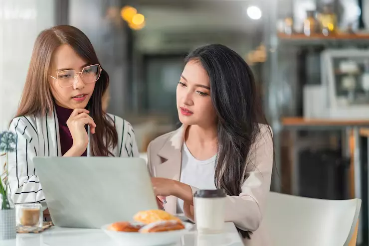 Two businesswomen reviewing documents together
